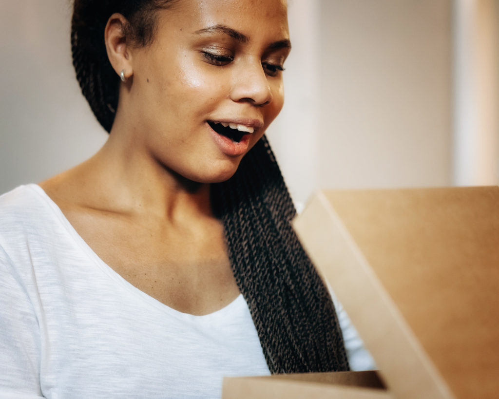 Woman opening package in delight